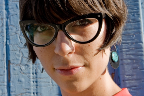 a close up portrait of julia wearing large cat eye glasses looking at the camera