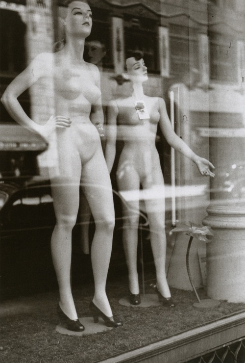 Two female mannequins stand undressed in a windowshop front in the 1940s. Photographed by John Vachon